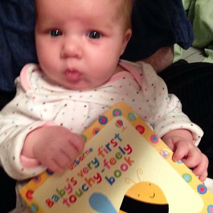 2 month old Rebekah Clay with a book