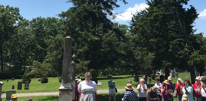 photo of reenactor performing in cemetery with audience