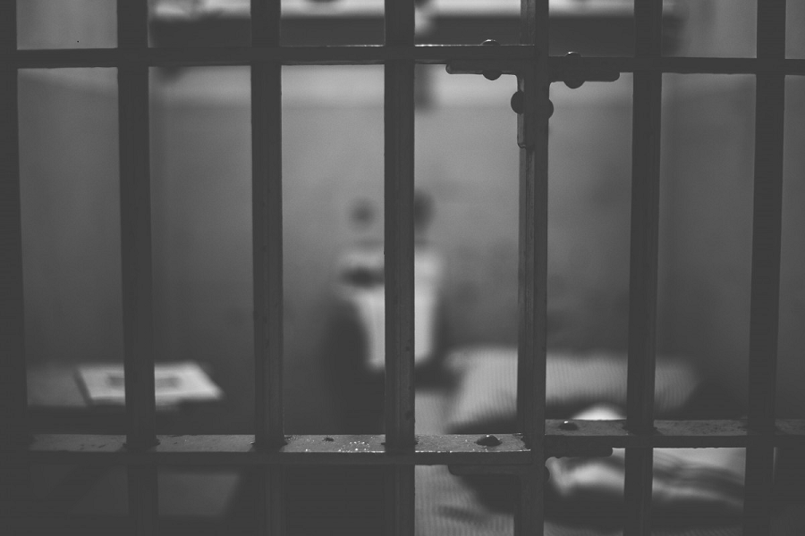 Photo of jail cell through Prison bars.