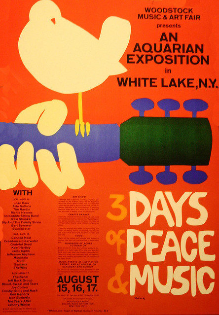 Woodstock poster, dove sitting on guitar neck, with words "3 days of peace and music" on orange background