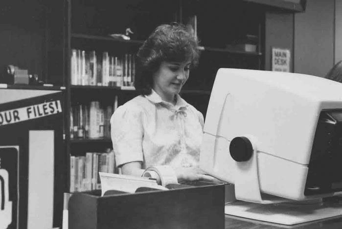 library staff member at 80s-era computer monitor