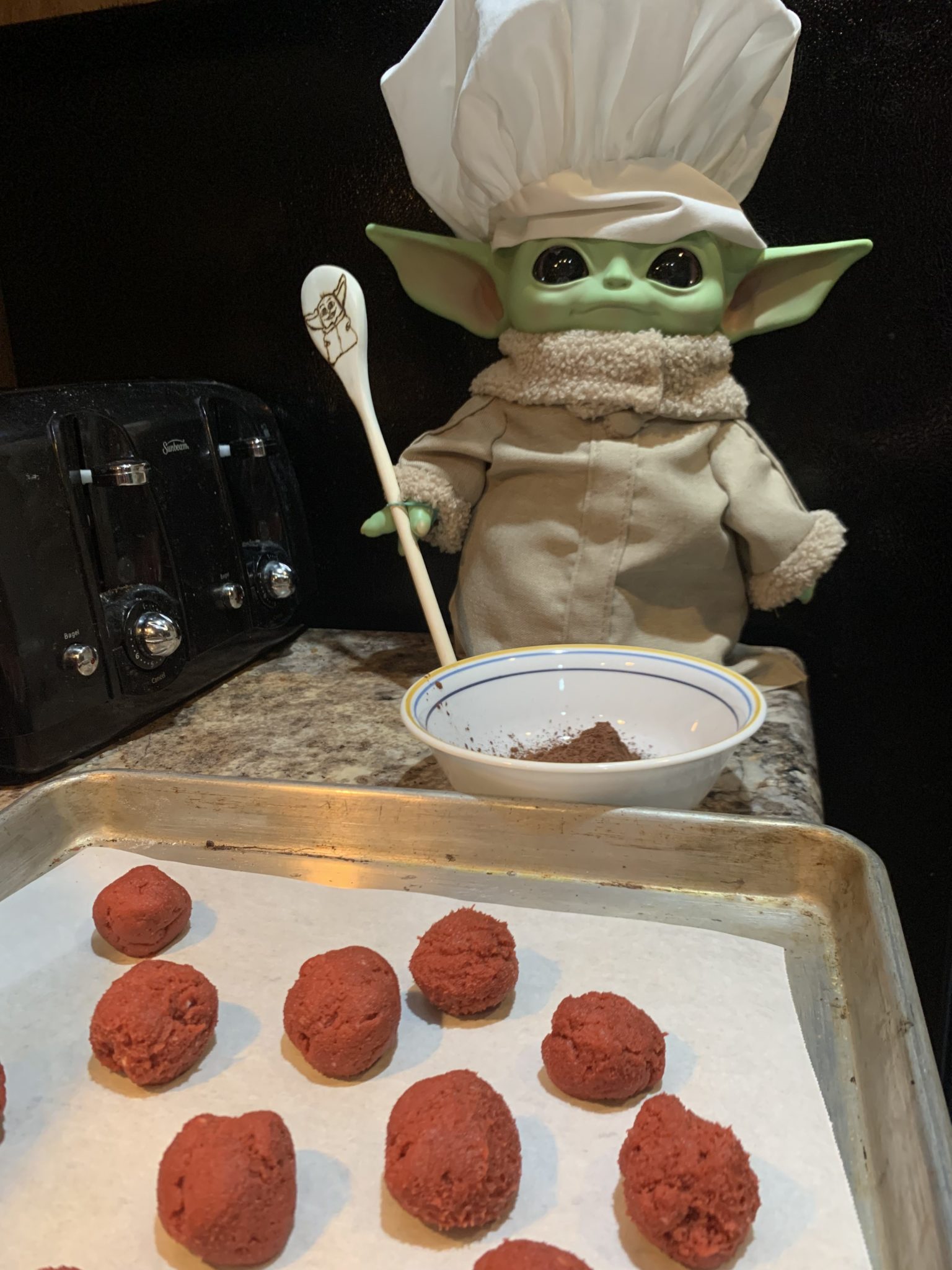 Grogu dressed as a chef with cookies.