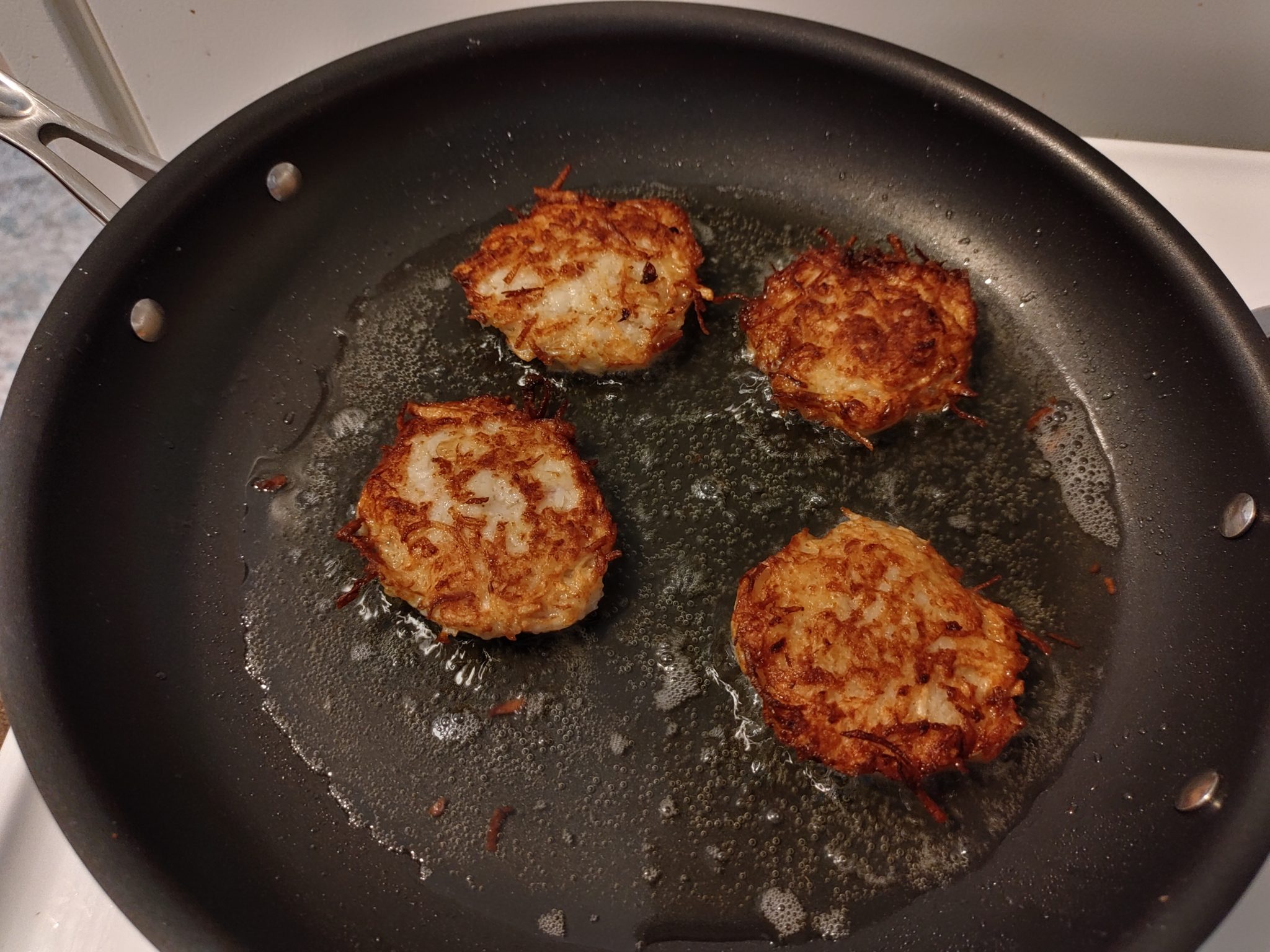 latkes frying in a pan