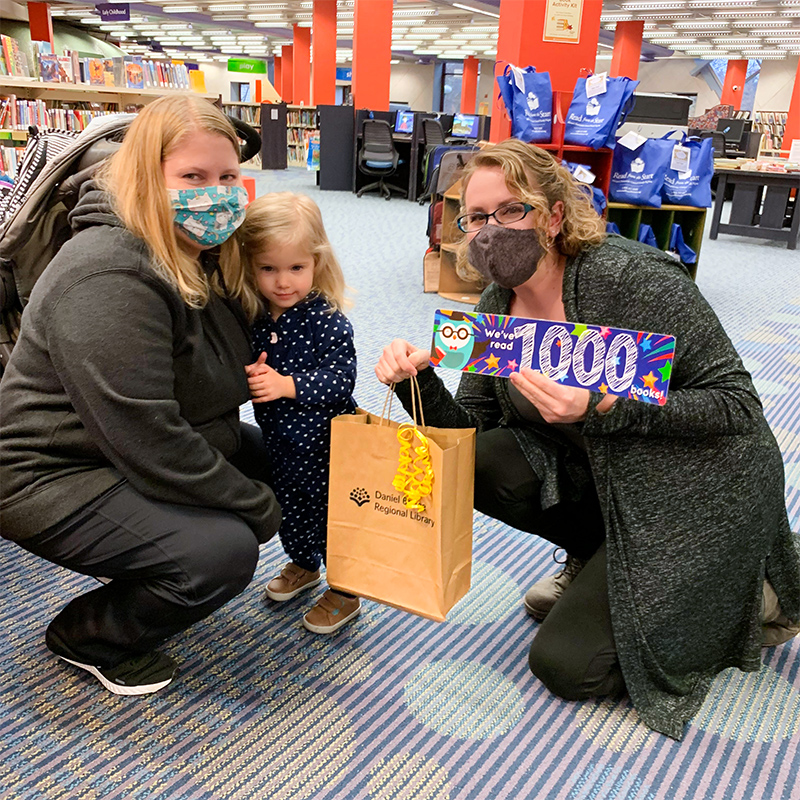 A participant in DBRL's 1,000 Books Before Kindergarten program receives a prize