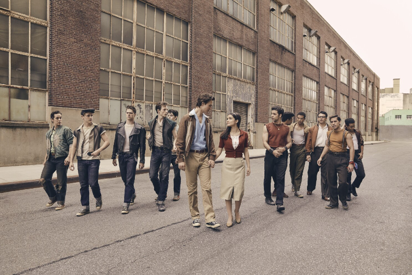 photo of Tony and Maria from West Side Story holding hands while members of each group stand behind them in a V formation