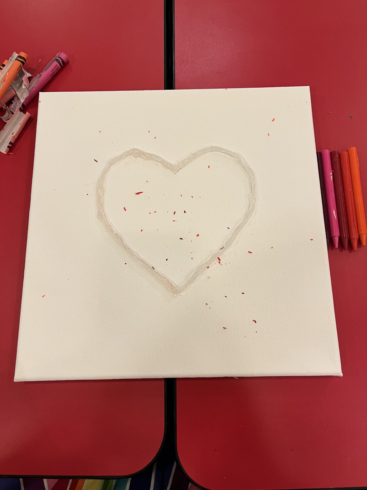 Outline of a heart in hot glue on canvas