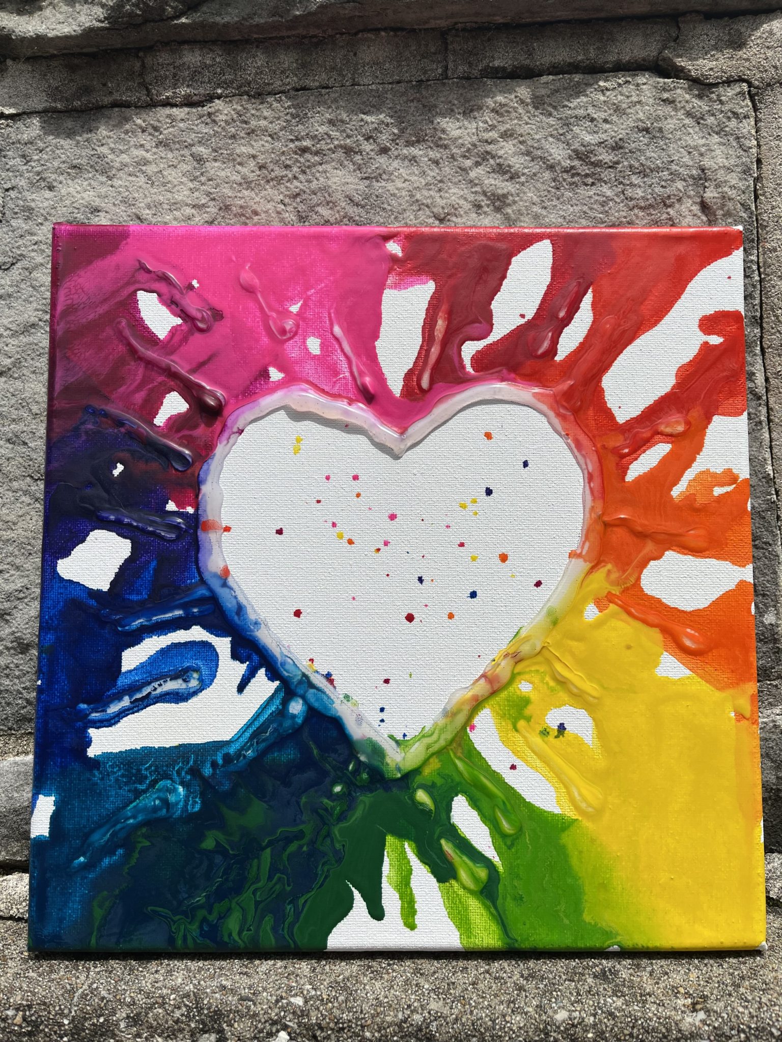 Melted crayons on canvas with a heart.