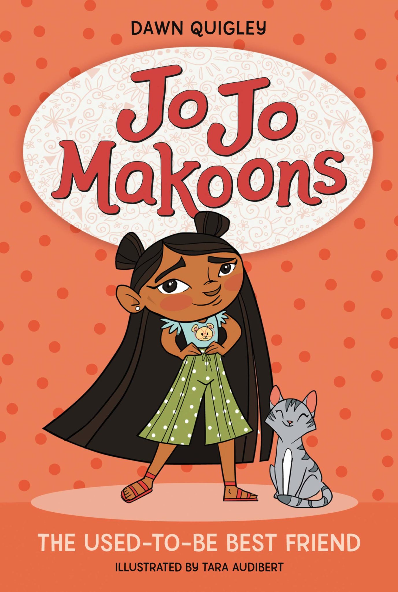 The cover of the book "Jo Jo Makoons: The Used-to-be Best Friend" features an illustration of a young Ojibwe girl and her gray cat. She wears her hair long with two buns and is wearing green pants and a t-shirt with a teddy bear on it. Her hands are on her waist as she smiles proudly.