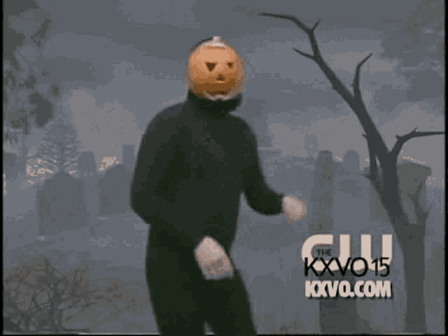 Gif of a person exuberantly dancing while wearing all black and a jack-o-lantern mask