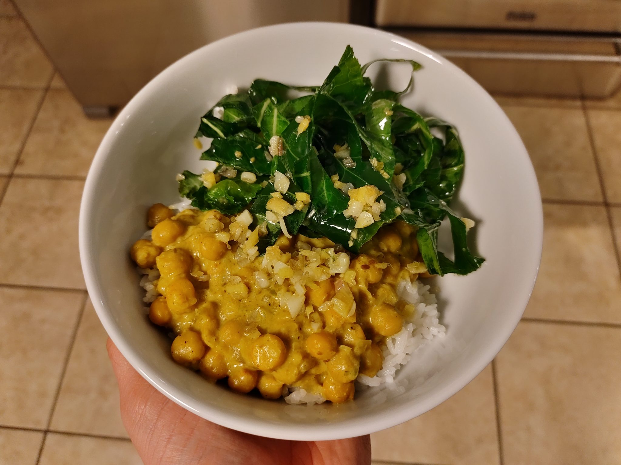 curried chickpeas with green in a white bowl