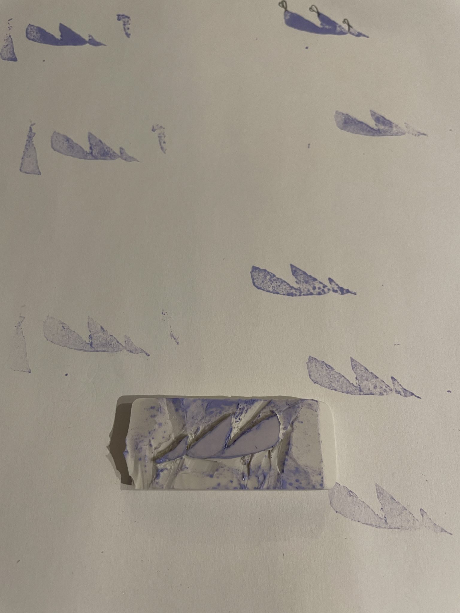 A white eraser carved with an curved abstract design, suggestive of three leaves, waves, sails, or goose bodies connected to one another. The carved eraser stamp sits on top of a white piece of paper, and the abstract design is stamped in lilac ink all over the page.