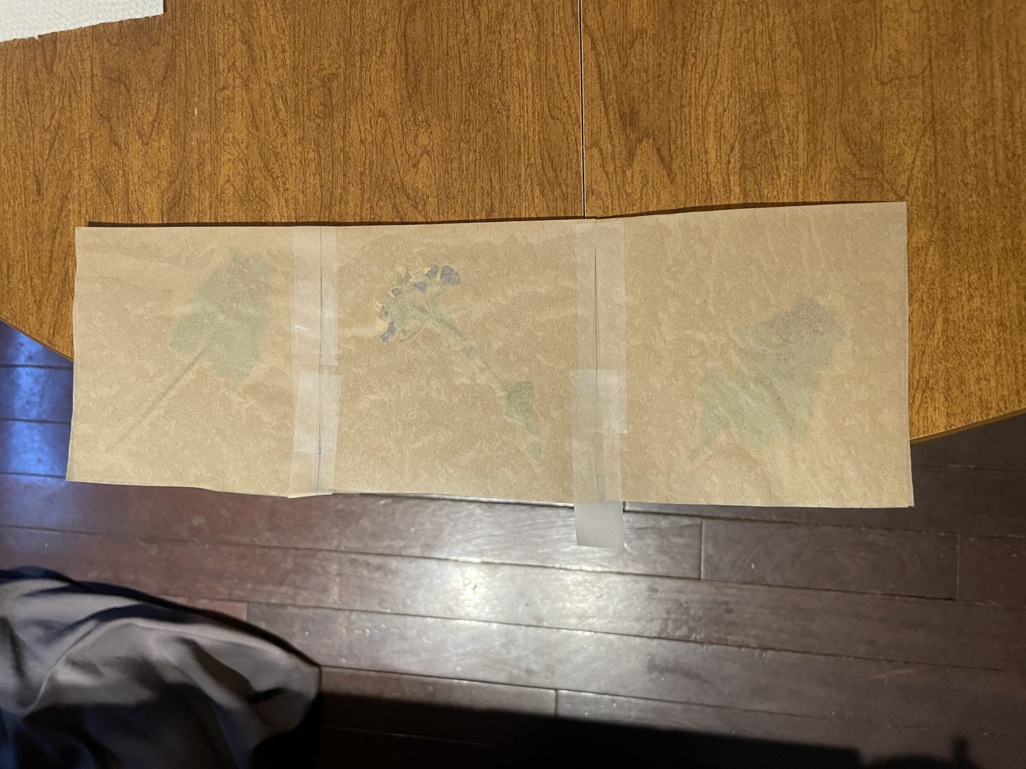 Photo of three squares of fused waxed paper laid out on a table and taped together.