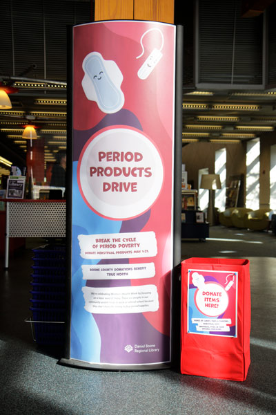 poster and drop-off box for period products drive in the lobby of the Columbia Public Library