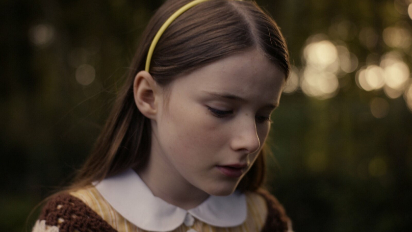 Image from The Quiet Girl film: young girl with brown hair looks downward