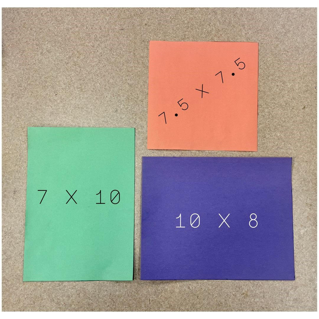  Three pieces of construction paper laid next to another to illustrate the three standard sizes found in children's picture book publishing. Clockwise from top left: a square orange piece of construction paper measuring 7.5 x 7.5 inches; a landscape-style purple piece of construction paper measuring 10 x 8 inches; and a portrait-style green piece of construction paper measuring 7 x 10 inches. 
