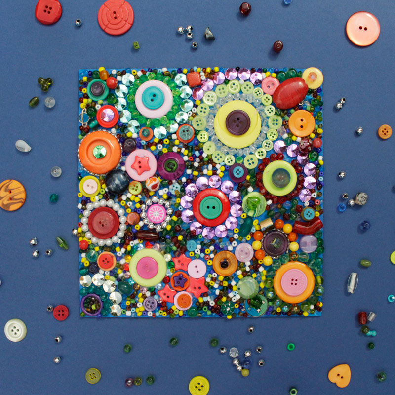 button and bead mosaic on dark blue background