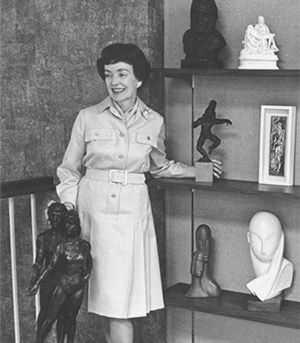 Virginia stands by a collection of small sculptures. (circa 70s)