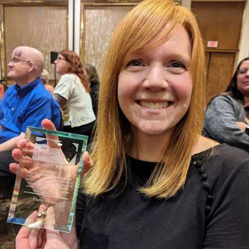 Lauren Williams smiles while holding her award