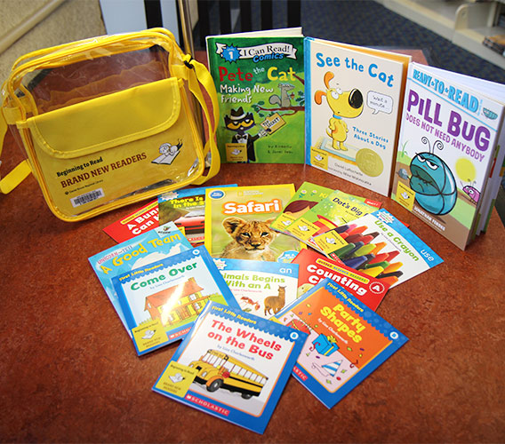 A beginning to read kit is displayed on a table along with the books it contains