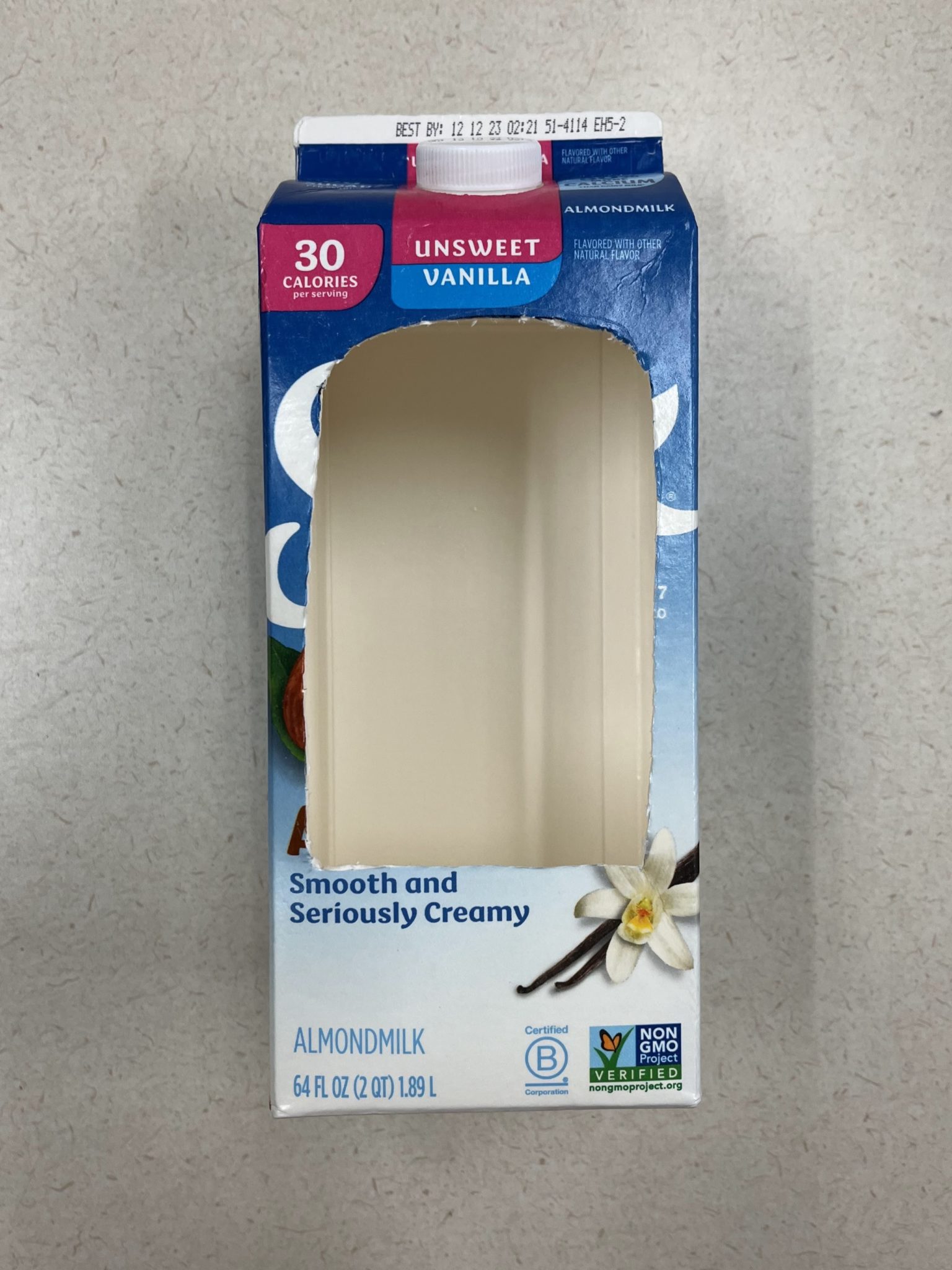 Bird feeder milk carton with hole cut.