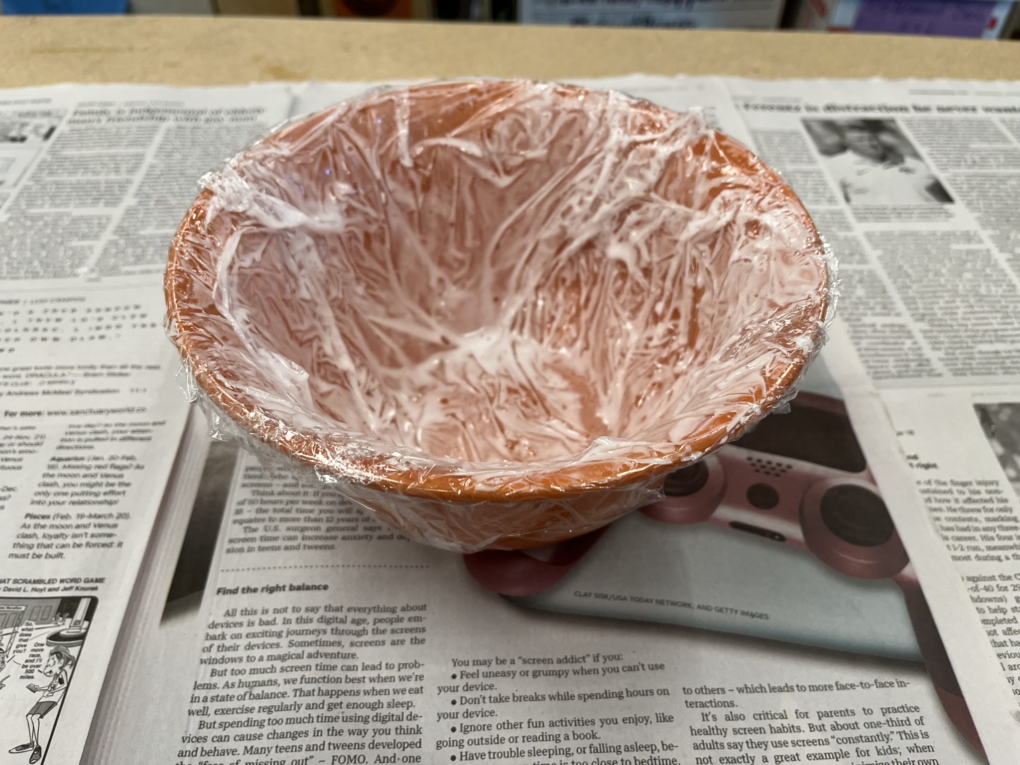 Bowl wrapped in plastic wrap with glue and water mixture pained on