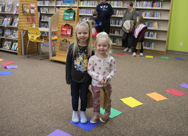 Two young children stand in the children's area of the Holts Summit Public Library