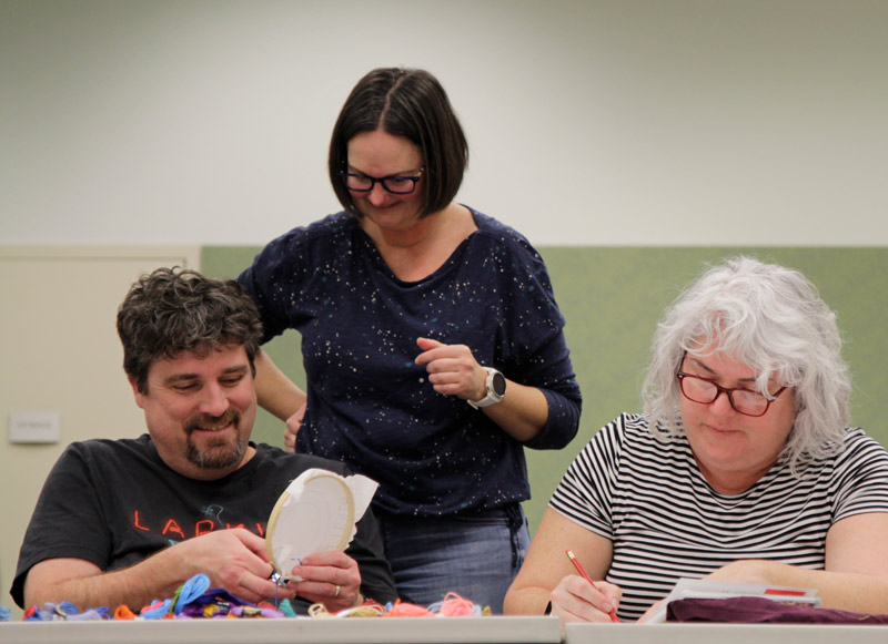 patrons socialize and learn a craft together at a library program