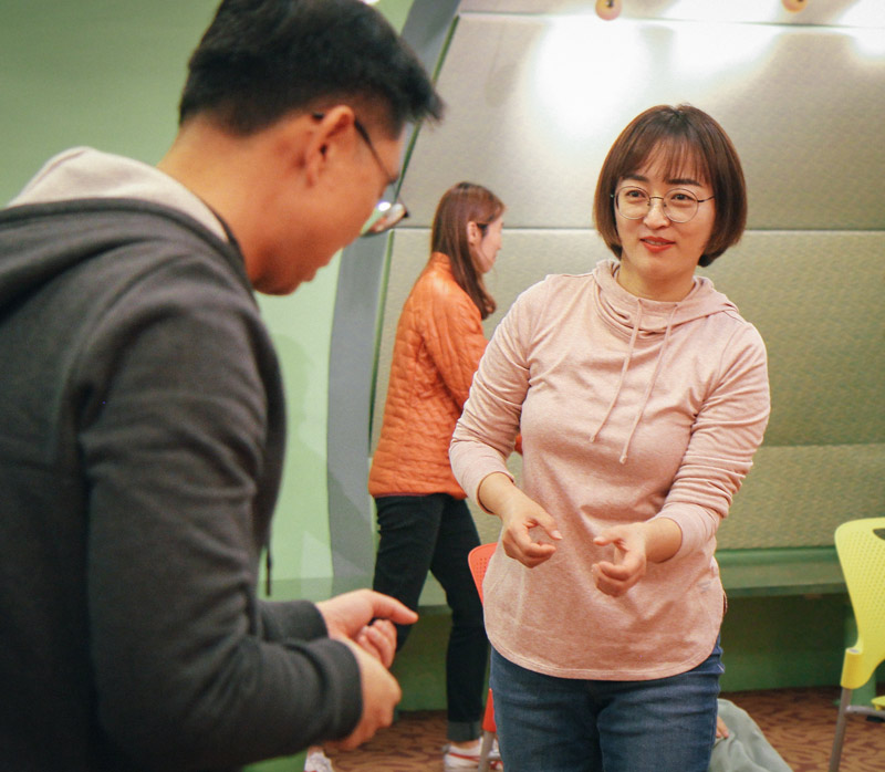 two patrons try out a mime activity at a library workshop