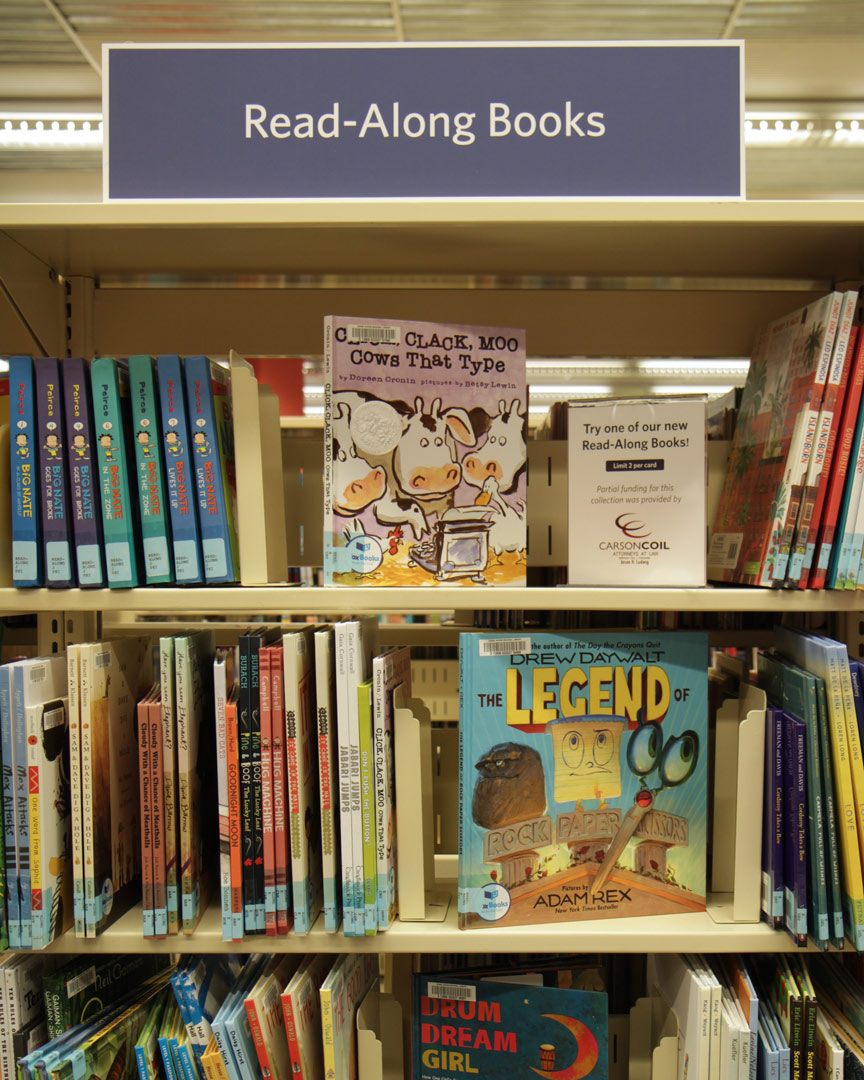 Shelves at DBRL with Wonderbooks. Sign at the top says "Read-alongs."