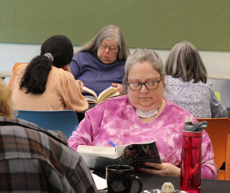 patrons read books at a library "book tasting" program