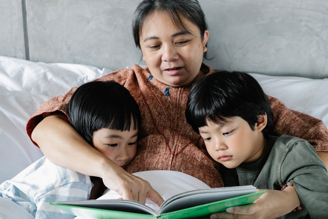 Two kids and an adult reading