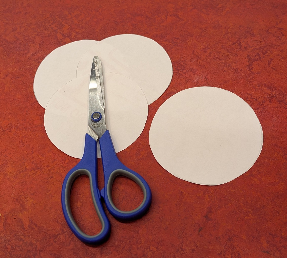 Four white paper circles, cut out.
