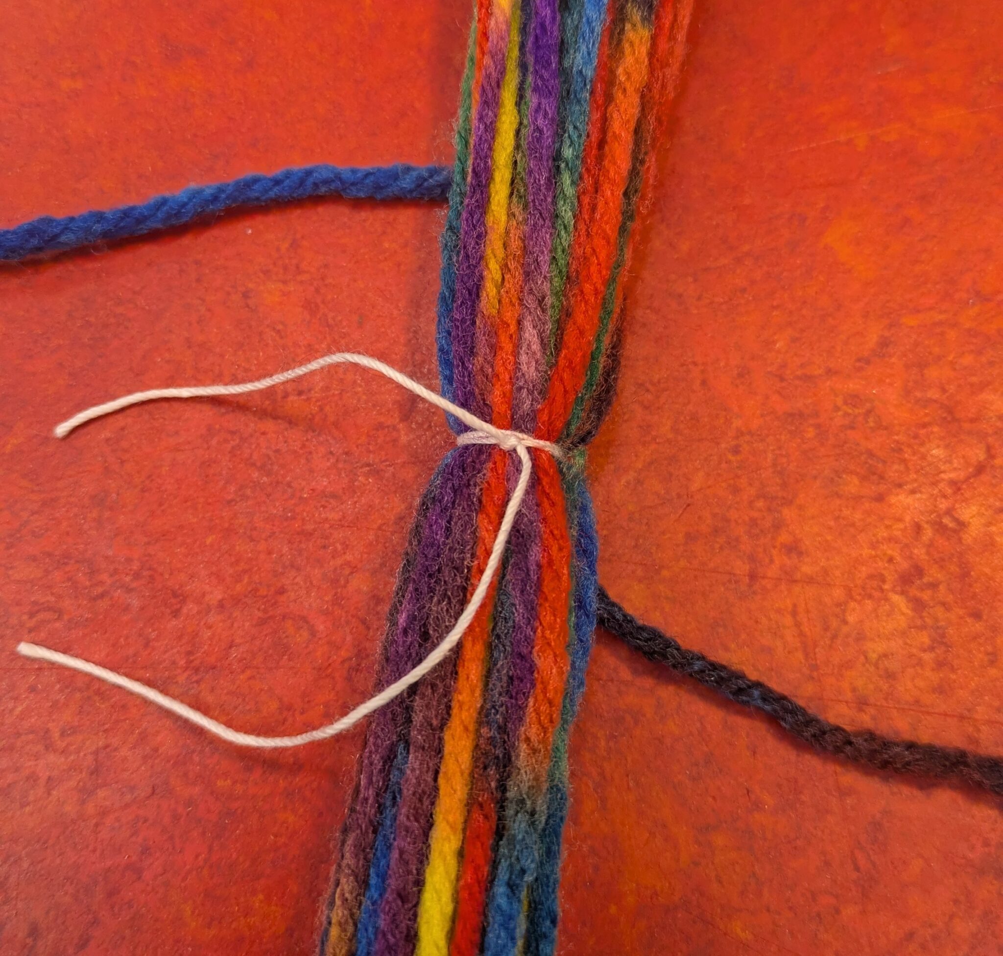 Knot tied with thread around yarn