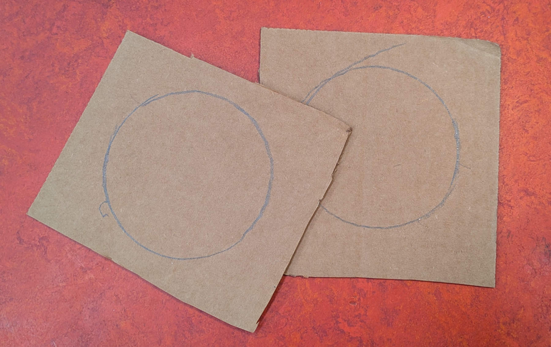 Two pieces of cardboard with circles traced on