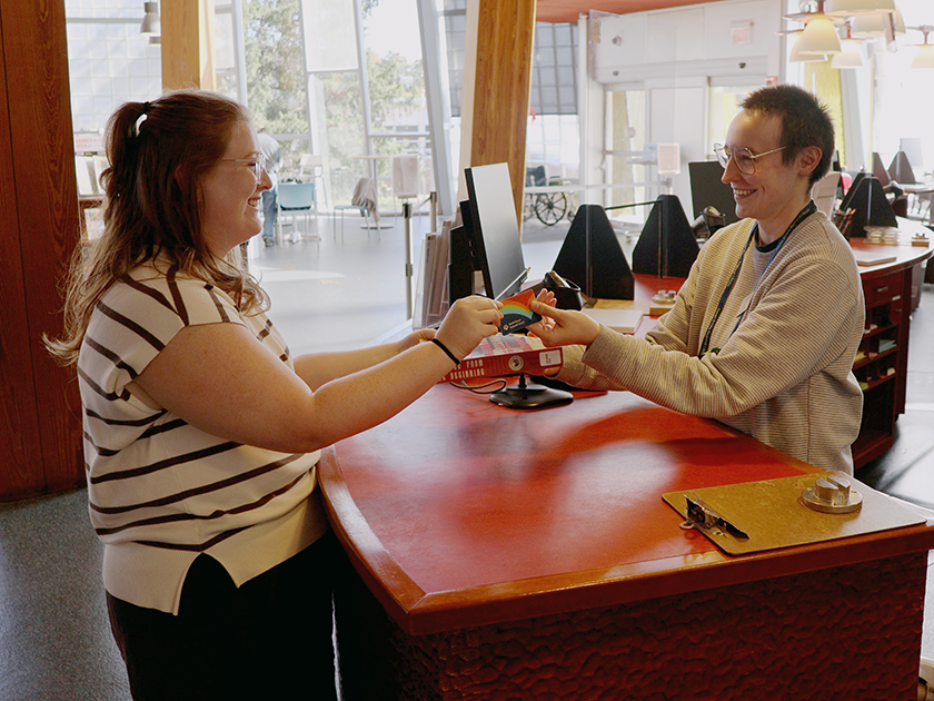 A patron borrows a book at the front desk of the Columbia Public Library