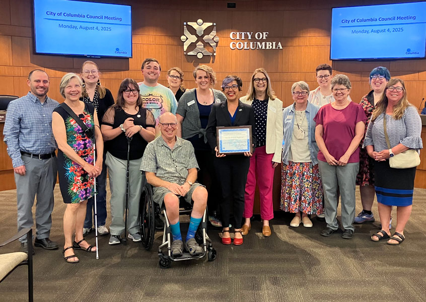 several library staff and Disabilities Commissioners pose with Director Robin Westphal and Mayor Barbara Buffalo who holds a framed certificate