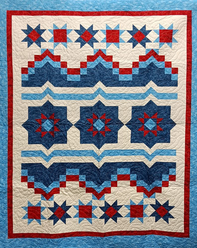 a quilt with red, white and blue geometric shapes
